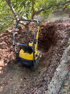 Miniexcavadora amarilla en zanja